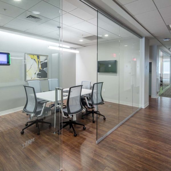 Glass walled conference room with table and chairs